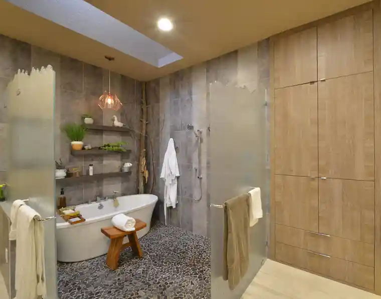 Hay's master bath with a stone wall, a soaking tub and a skylight
