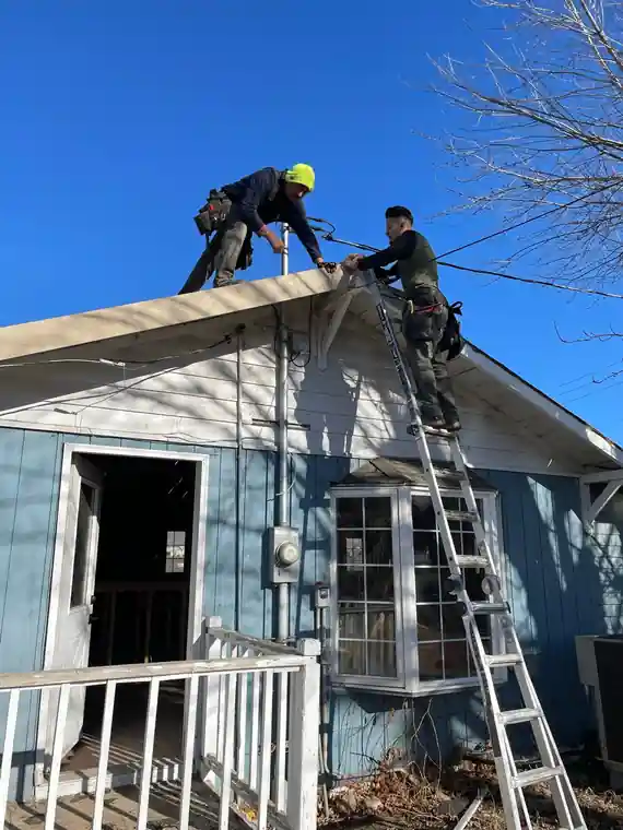 A crew working on the Selah cottage roof, seen from a distance