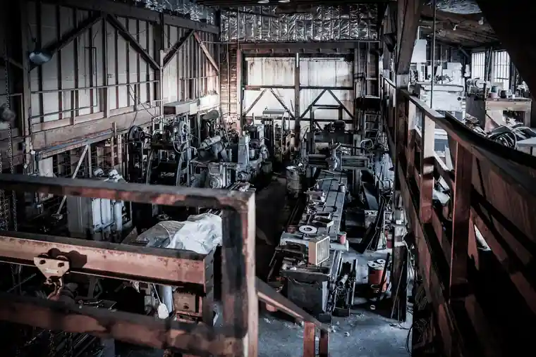 The old machine shop floor with lathes and belts under tall factory windows