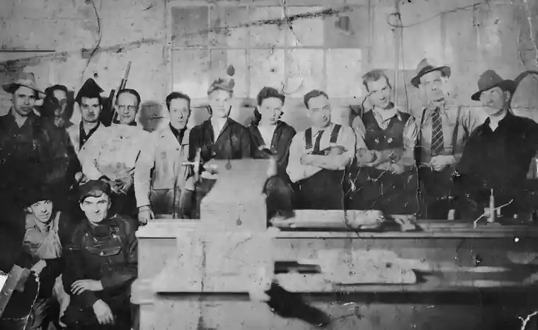 Archival photo of the McIlvanie Machine Works crew posed inside the shop