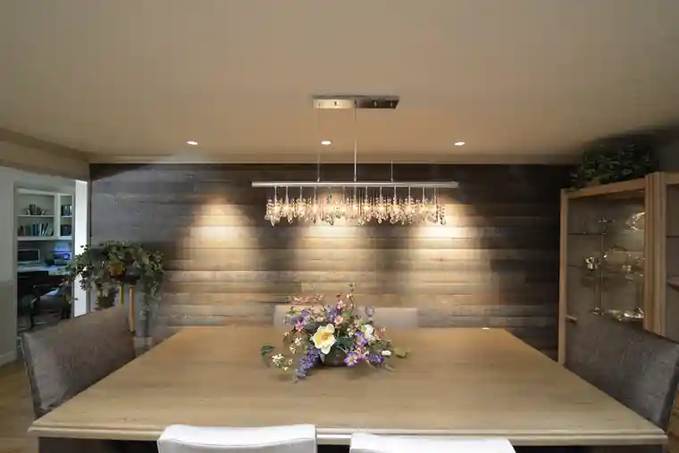 Burley dining room with a reclaimed plank wall and a linear chandelier