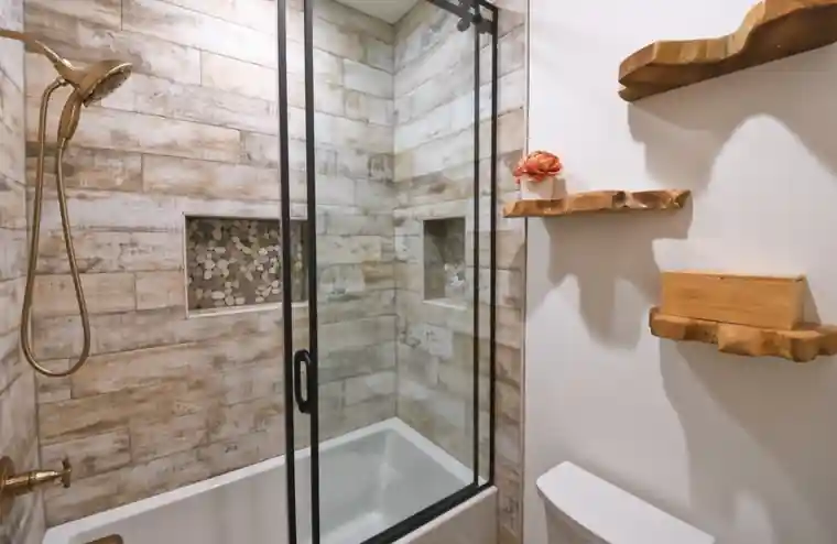 Finished tile shower with a clean glass panel in a bathroom by M.B. Designs