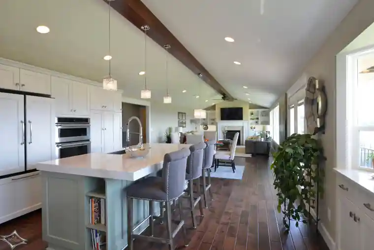 Burley kitchen with a white island under timber beams