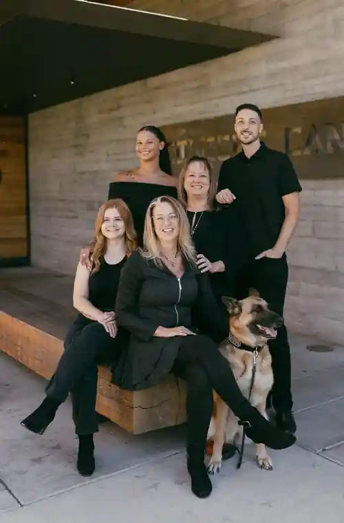The M.B. Designs team seated on a bench outside the building